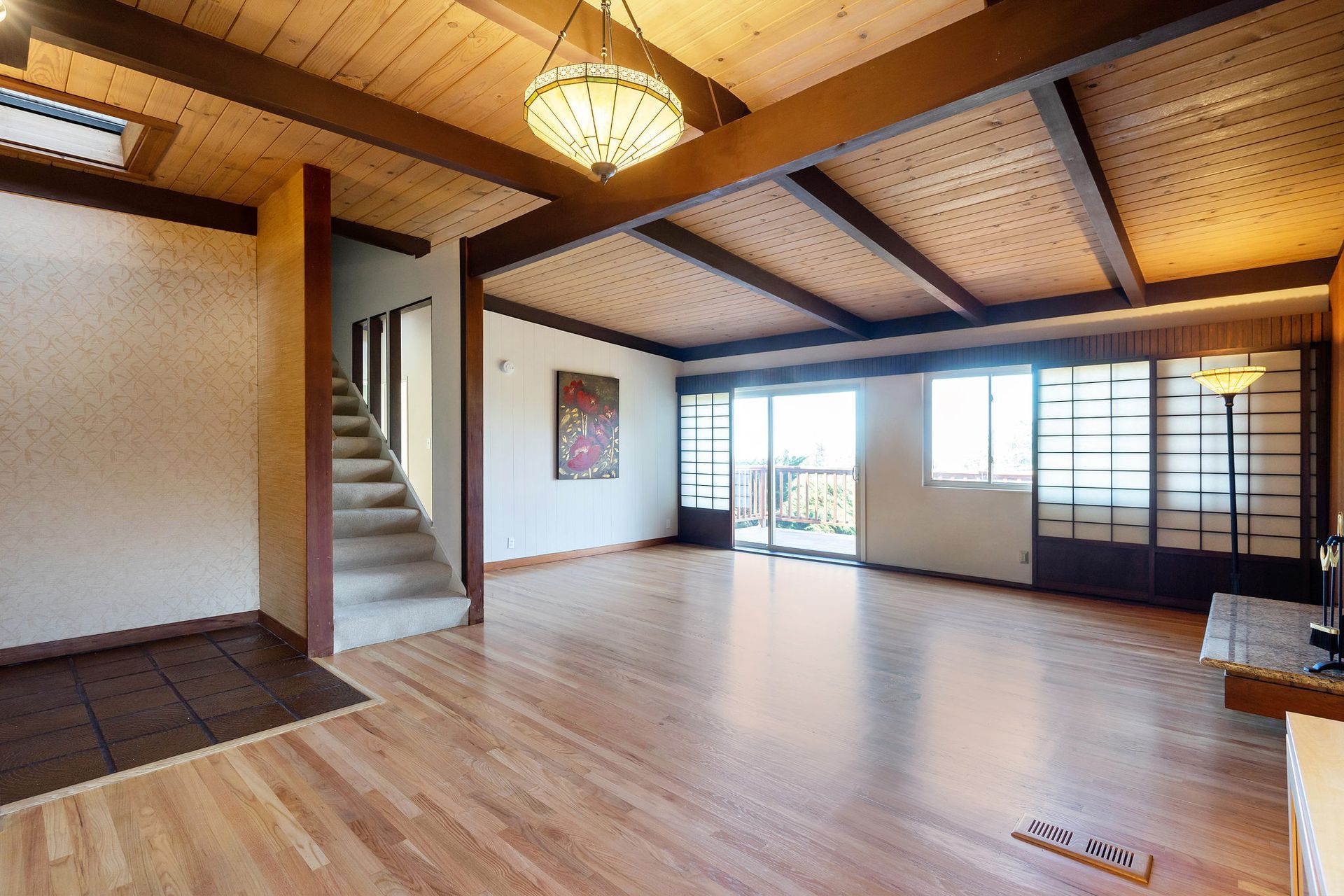 An empty living room with hardwood floors and stairs