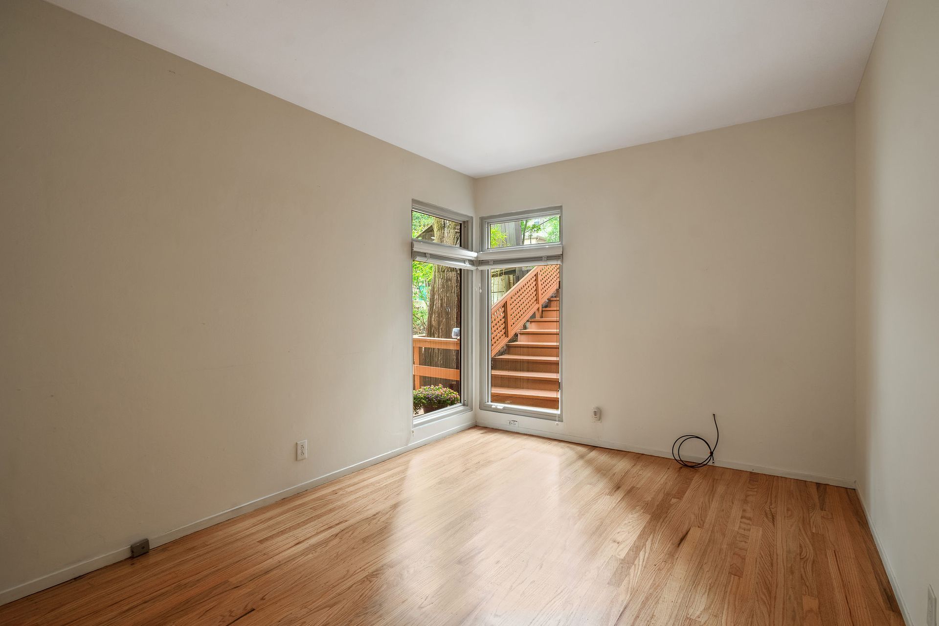 An empty room with hardwood floors and white walls.
