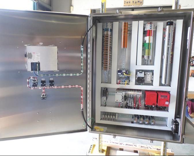 a stainless steel control panel with a lot of wires coming out of it