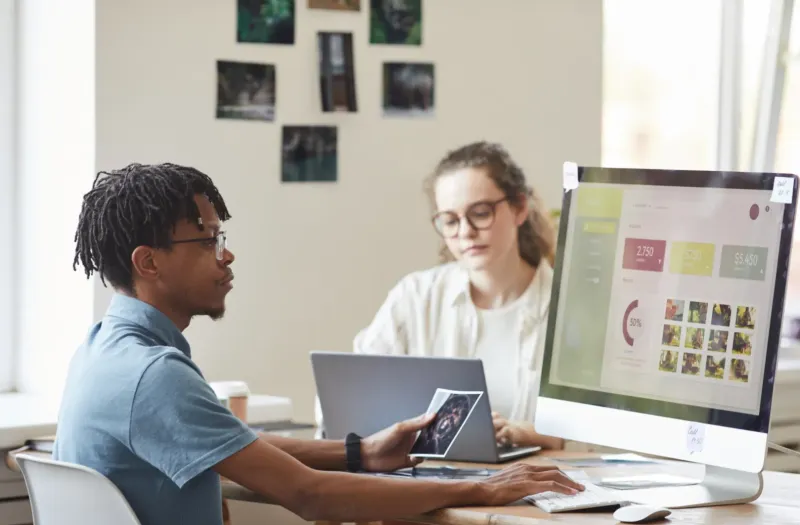 Man and woman reviewing SEO strategy on computer screens in a bright Tucson office, planning a lead generation campaign.