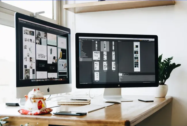 Two monitors side by side on an office desk, representing a Tucson website leasing setup.