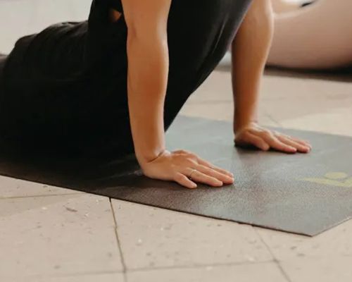 A person is doing push ups on a yoga mat.