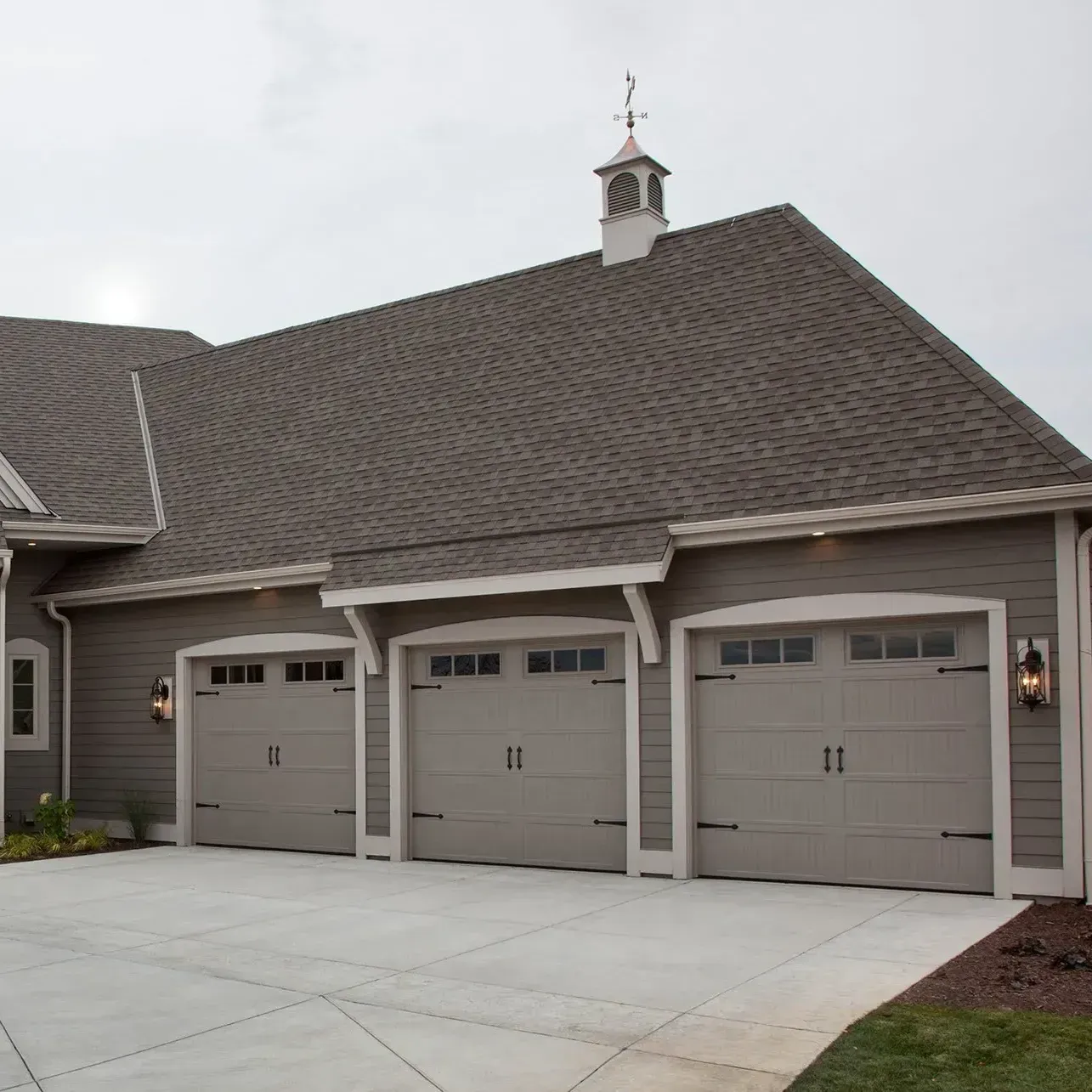 A house with four garage doors and a chimney on the roof