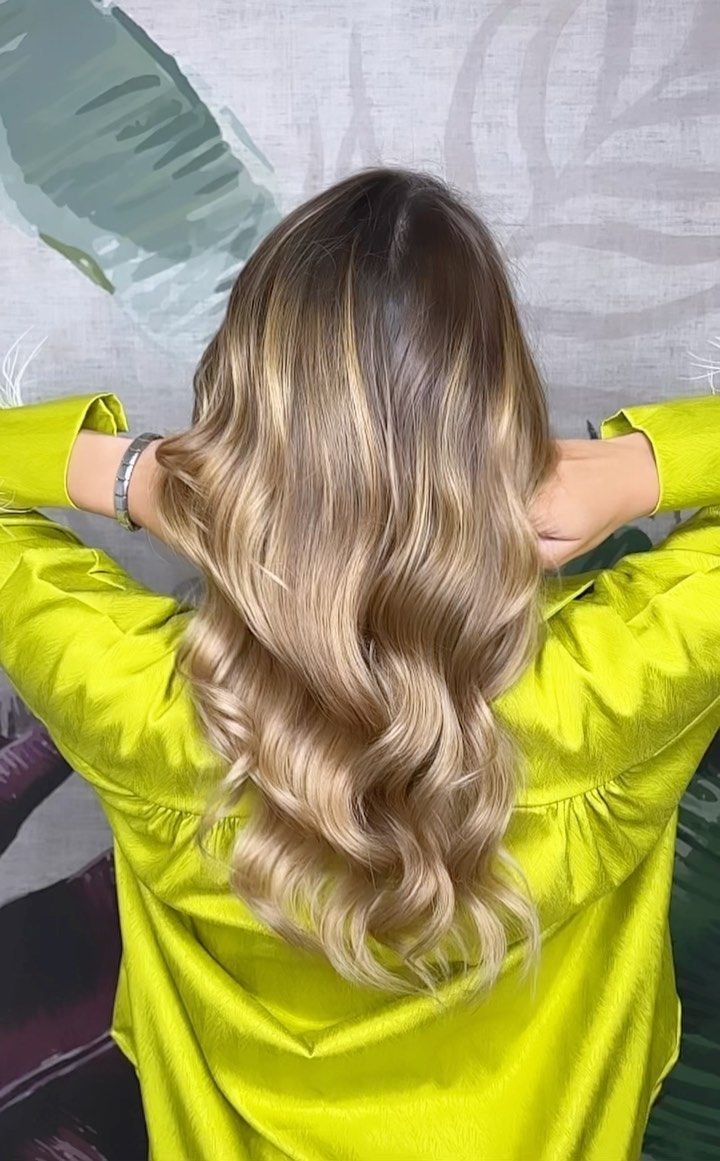 Una donna con lunghi capelli biondi indossa una giacca gialla.