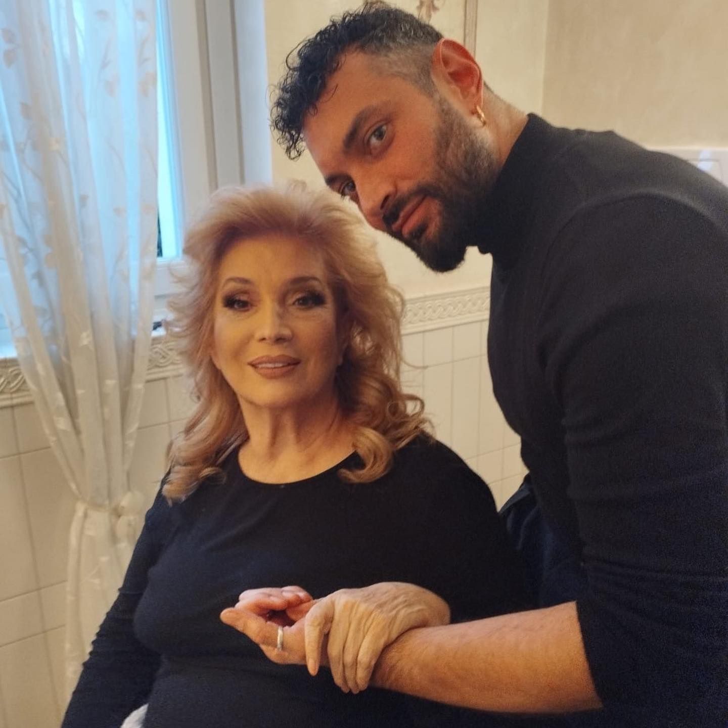 Un uomo è in piedi accanto a una donna con una camicia nera