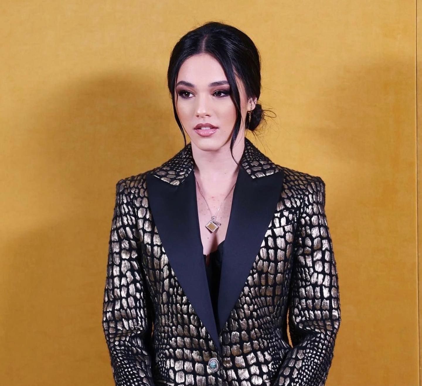 Una donna indossa una giacca nera e oro