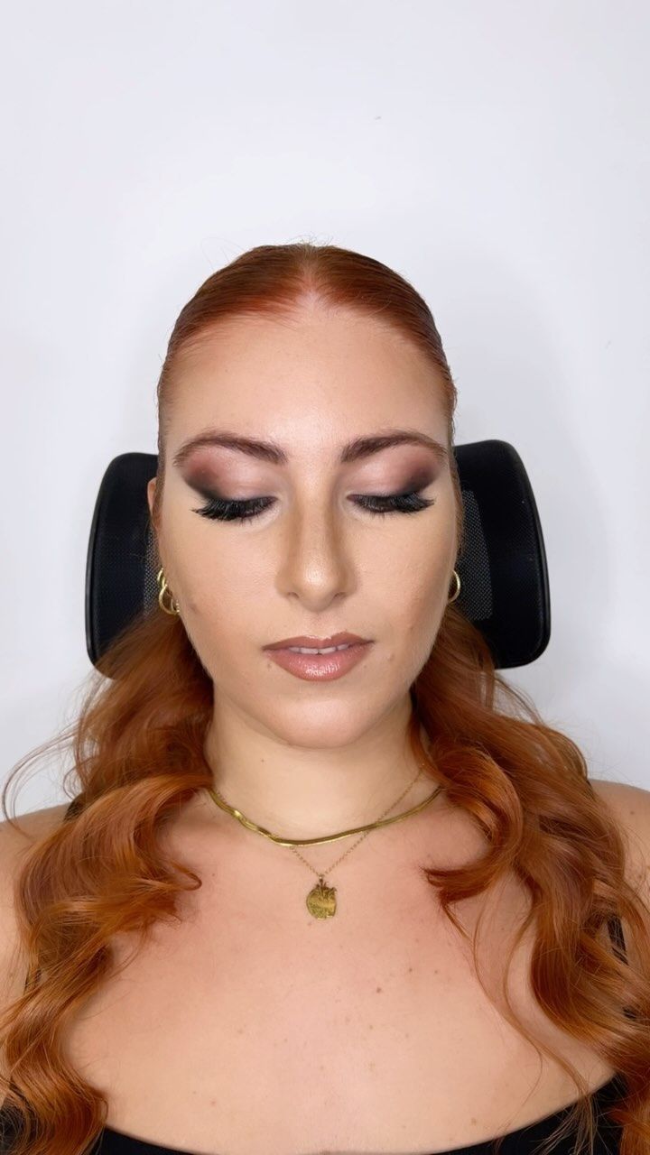 Una donna con i capelli rossi indossa una collana e degli orecchini.