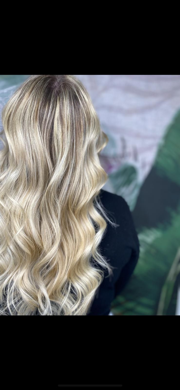 Un primo piano dei capelli biondi di una donna in un salone.