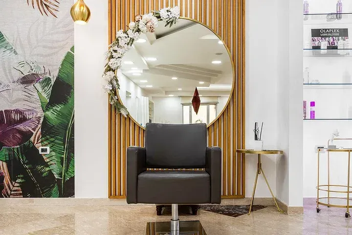 Una sedia in un salone con un grande specchio sul muro.