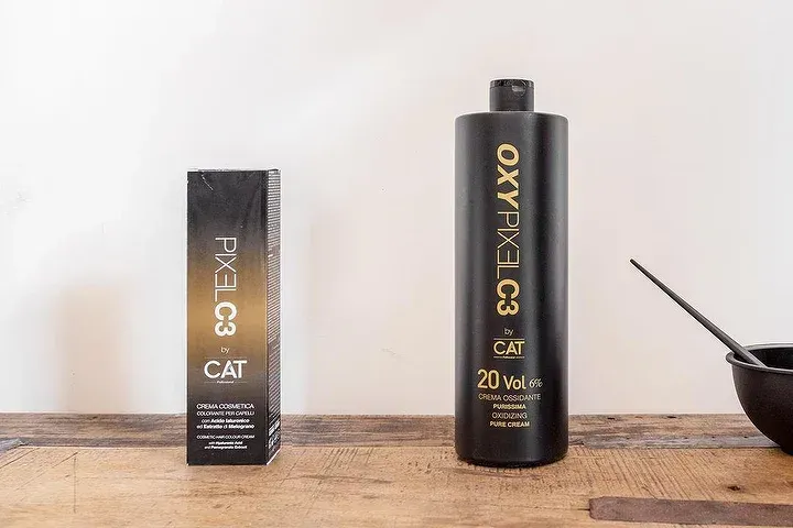 Una bottiglia di ossidante e una scatola di ossidante sono su un tavolo di legno.