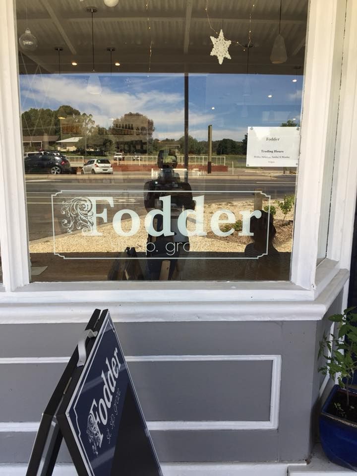 A window with a sign that says ' fodder ' on it