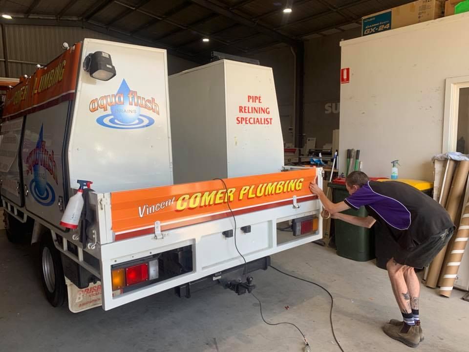 A man is working on the back of a truck in a garage.