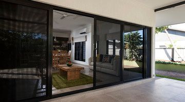 Sliding glass doors open onto a patio, revealing an interior with a living room and dining area.