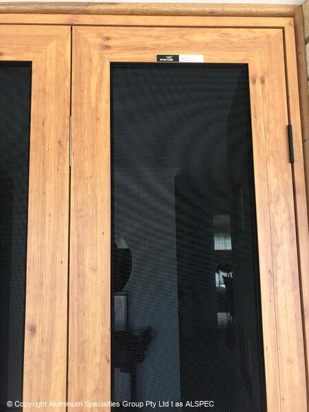 Wooden double doors with black screen inserts.