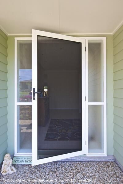 White screen door ajar, flanked by frosted glass panels, set in a green-painted doorway.