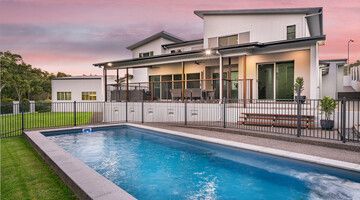 A screened in swimming pool with a view of a lake