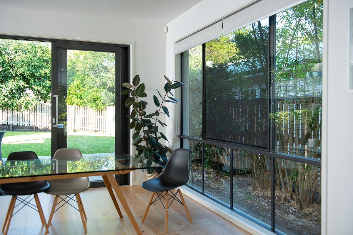 A blurry picture of a deck with a table and chairs behind a screen.