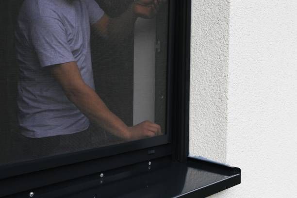 Craftsman mounts a security screen window in a home.