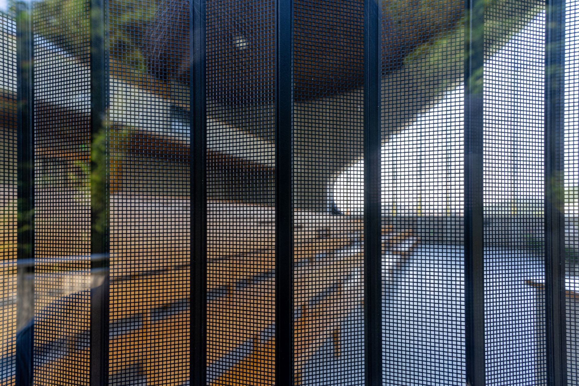 A close up of a metal fence with a blurred background.