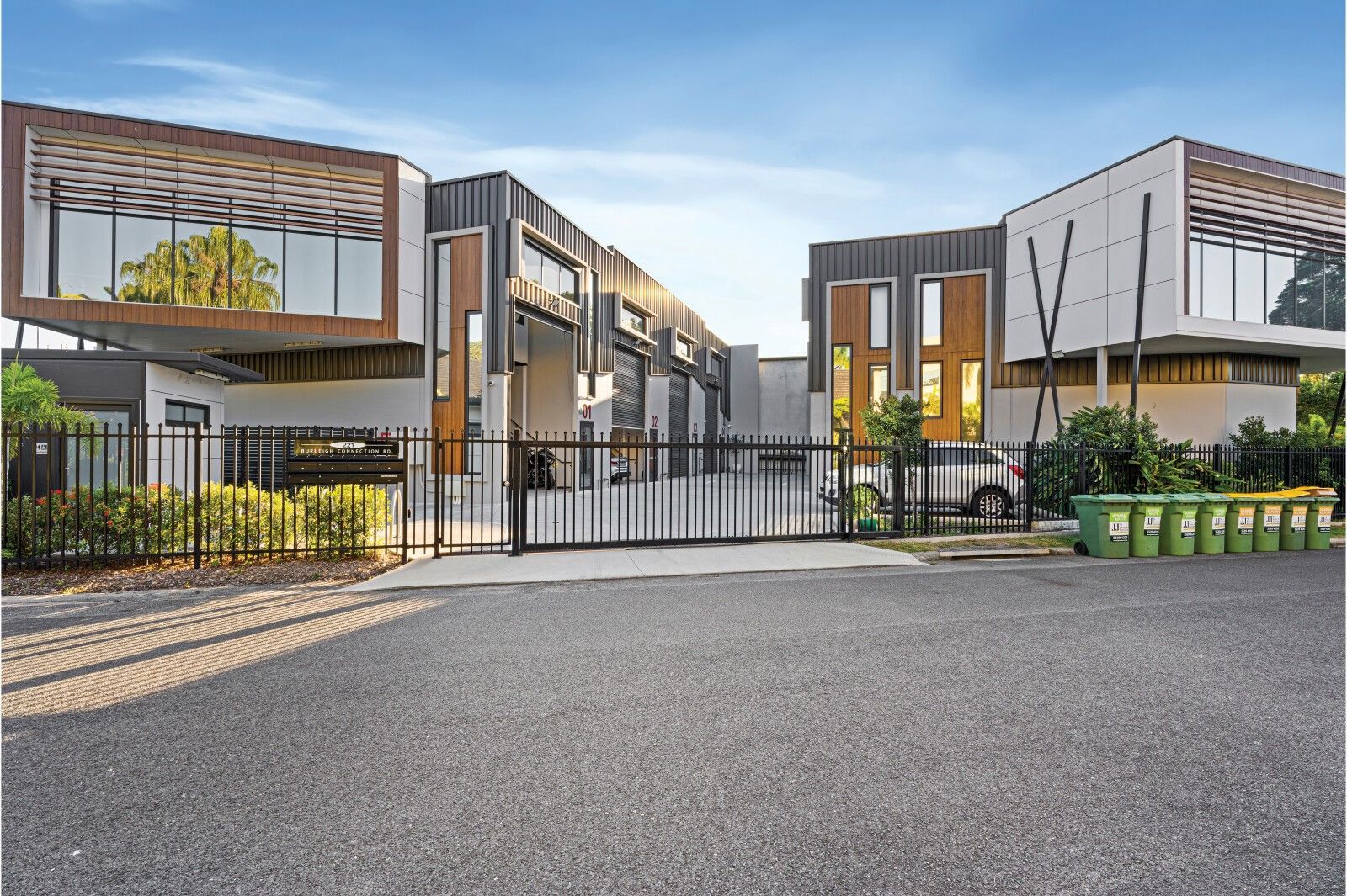 Modern multi-unit buildings with dark exteriors and a gated entrance.