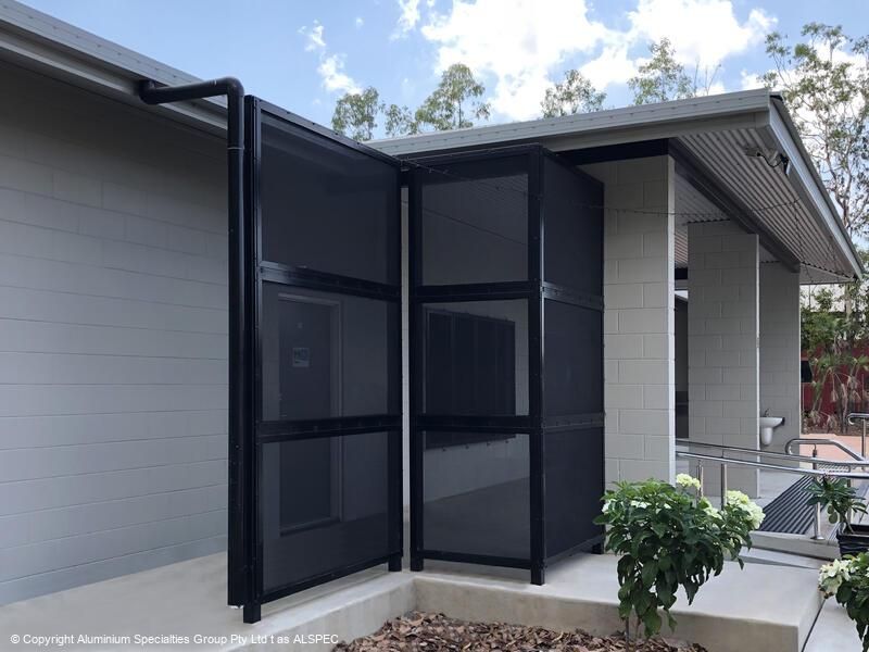 Black mesh screen doors, mounted on a building's exterior, partially open.