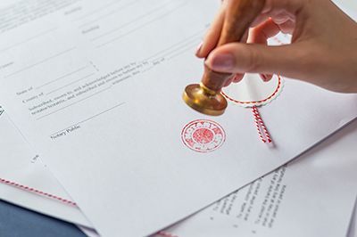A person is stamping a document with a notary stamp.