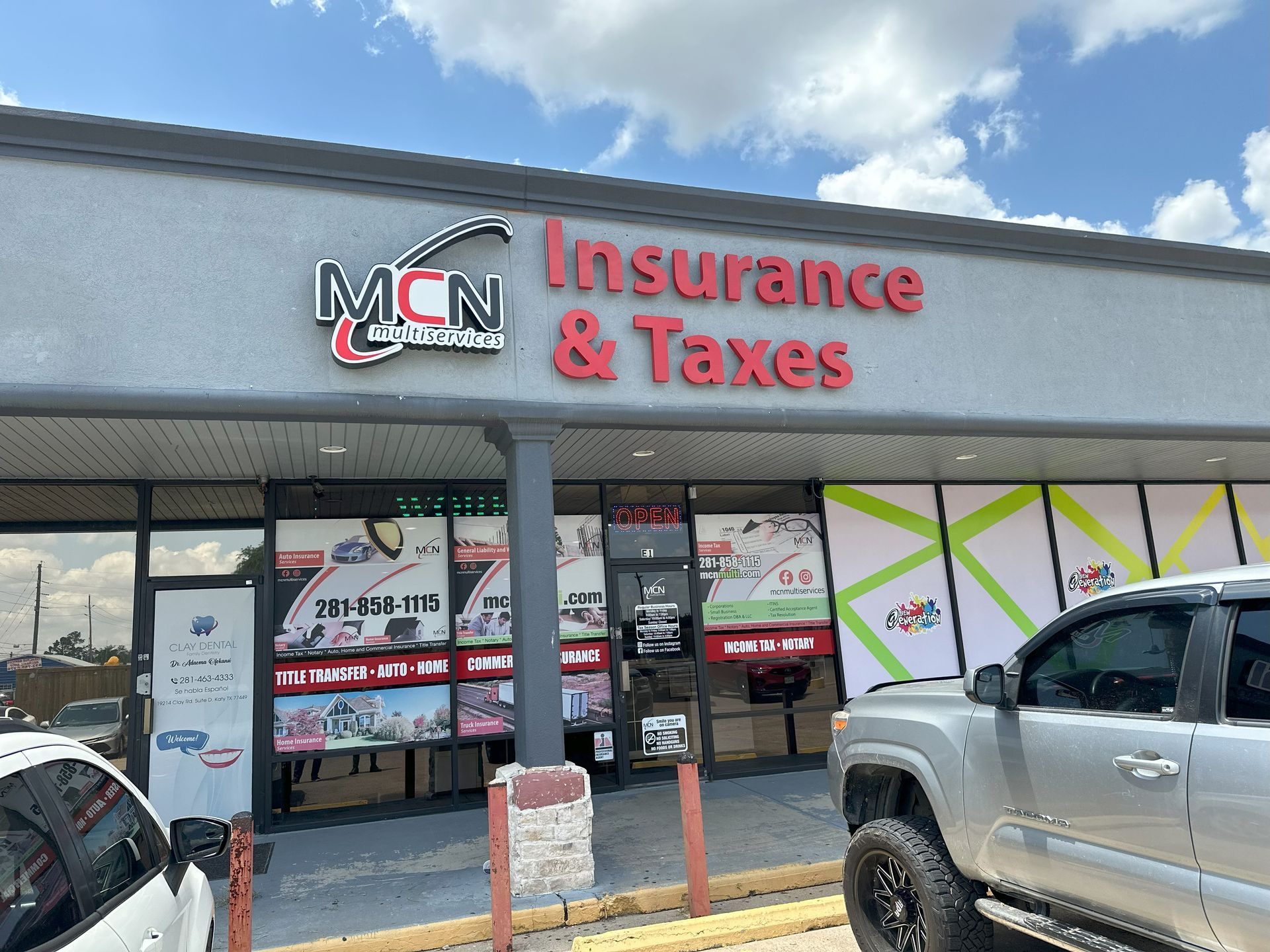 A truck is parked in front of a building that says insurance and taxes.