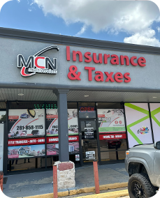 A truck is parked in front of a building that says mcn insurance & taxes