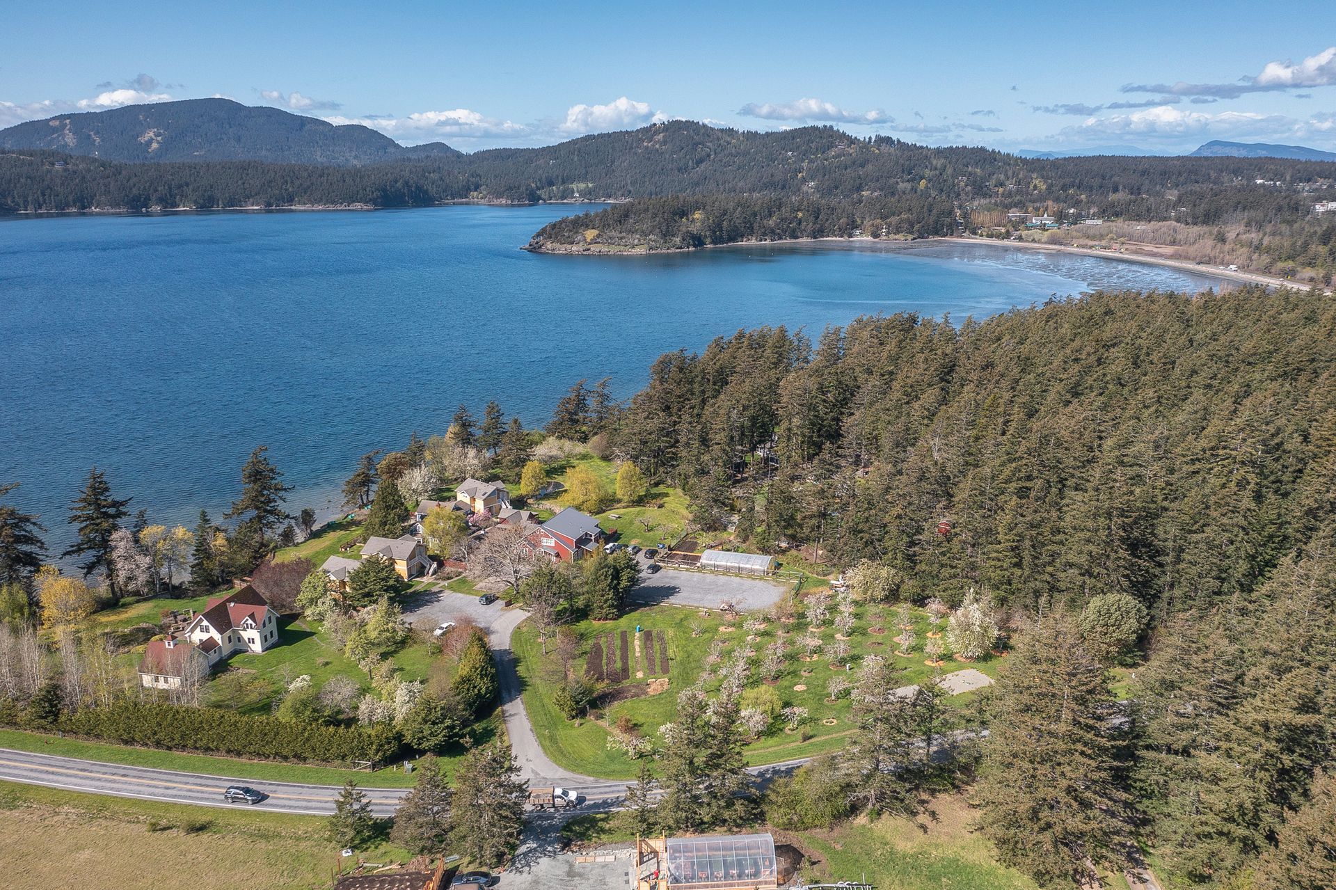 A fence surrounds a body of water with mountains in the background.