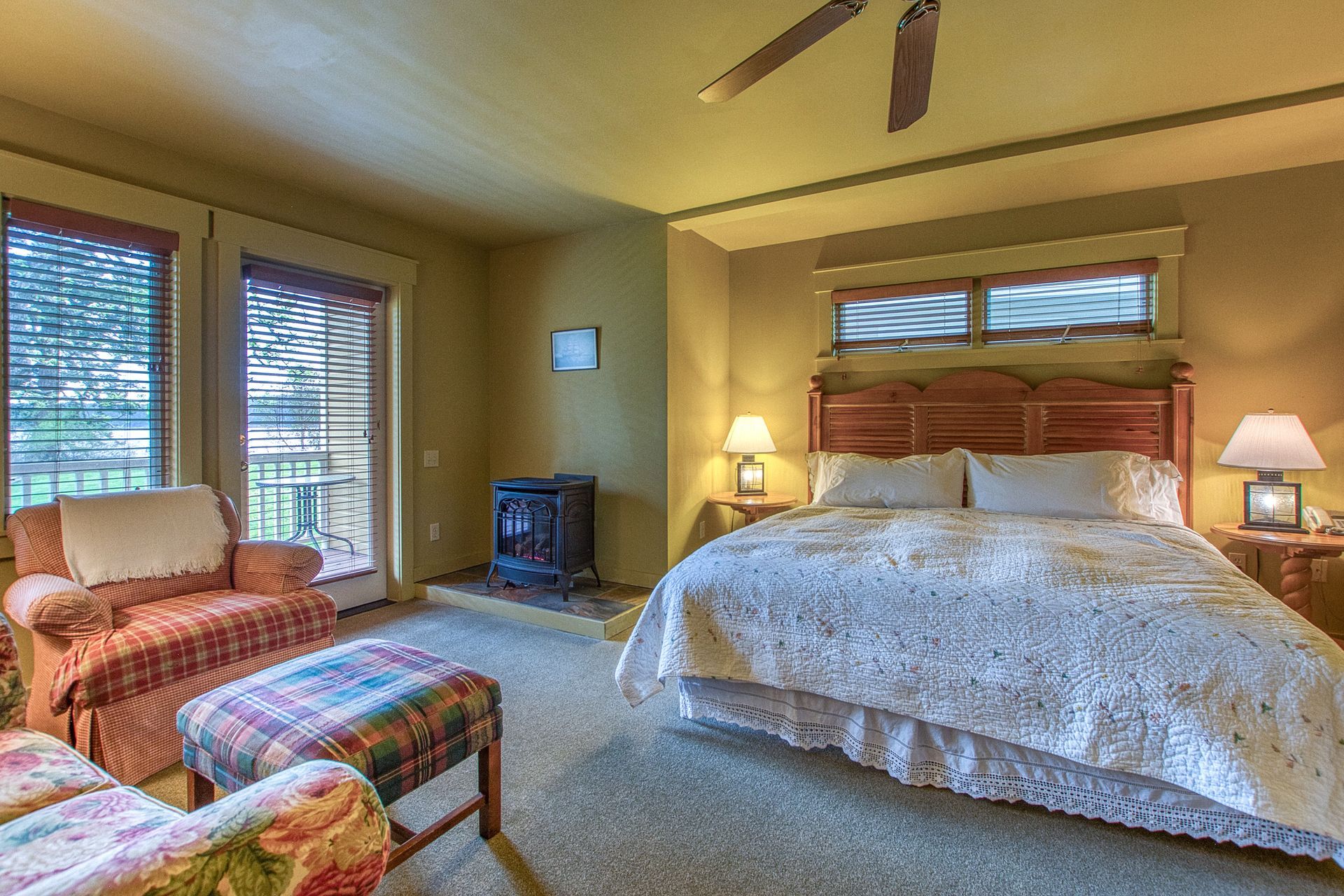 A bedroom with a king size bed and a ceiling fan.