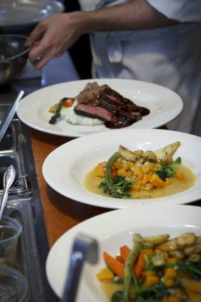 A chef is preparing plates of food on a table