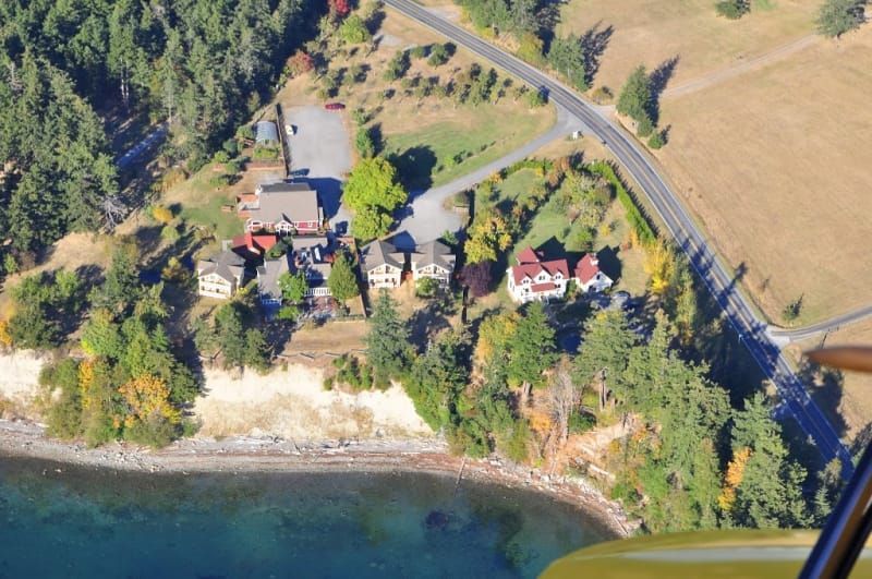 An aerial view of a house on the shore of a lake