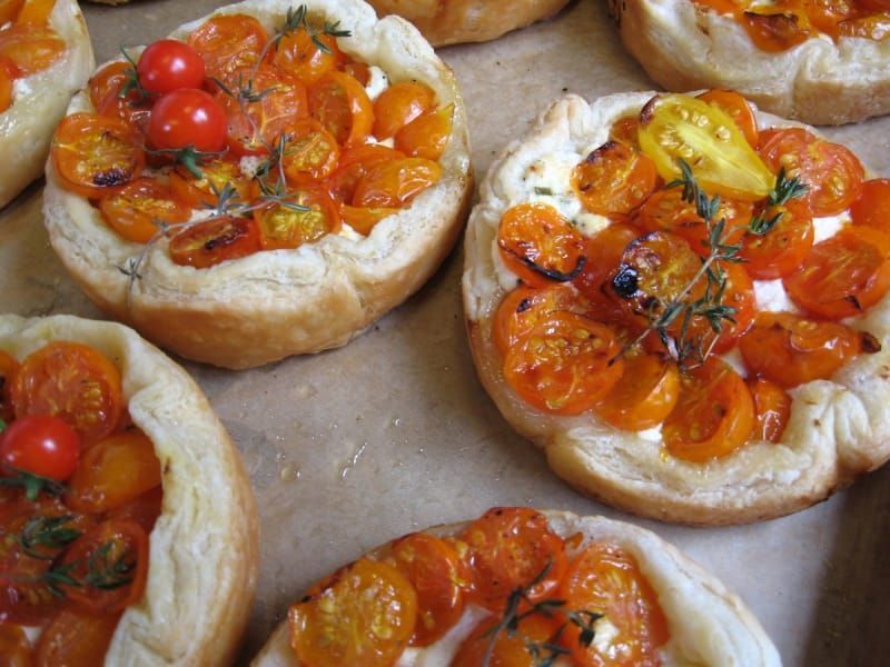 A bunch of pizzas with tomatoes and cheese on them