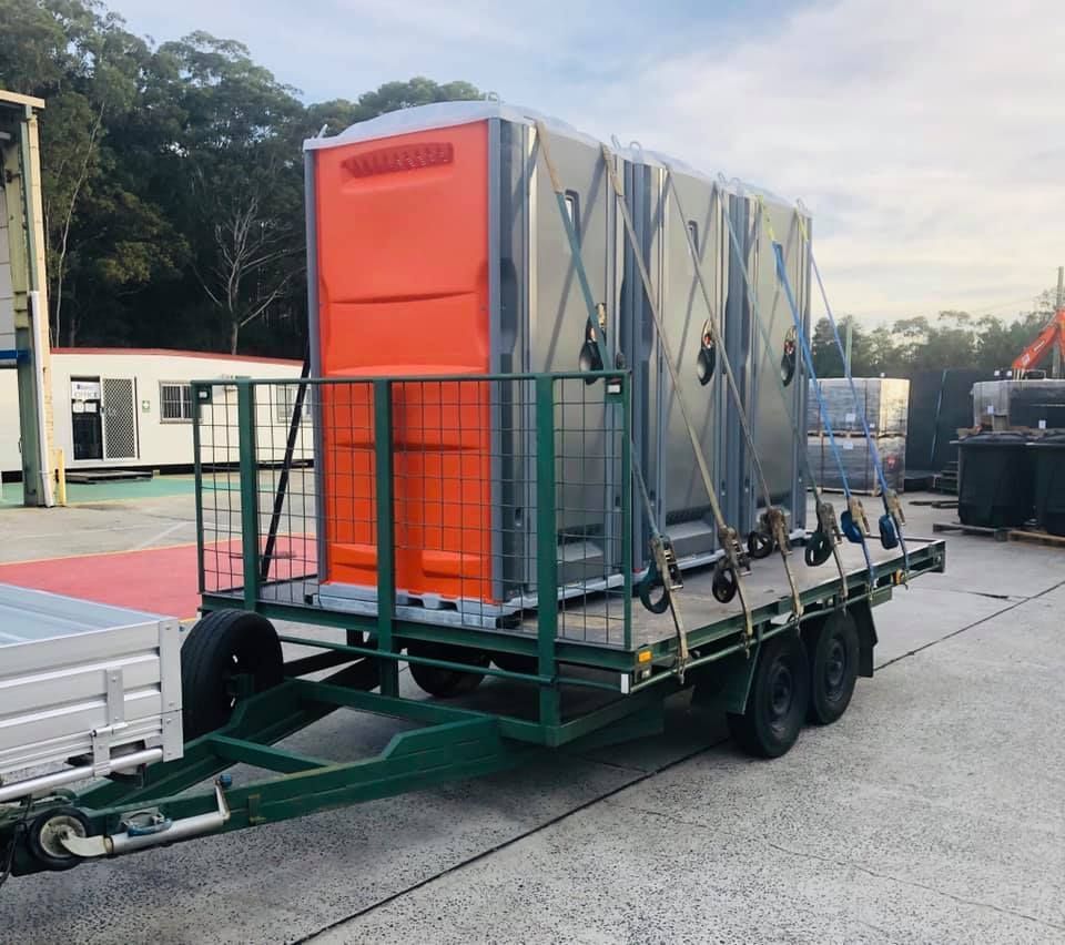 A Trailer With A Portable Toilet On It — Coffs Temporary Fencing Pty Ltd In Moonee Beach, NSW