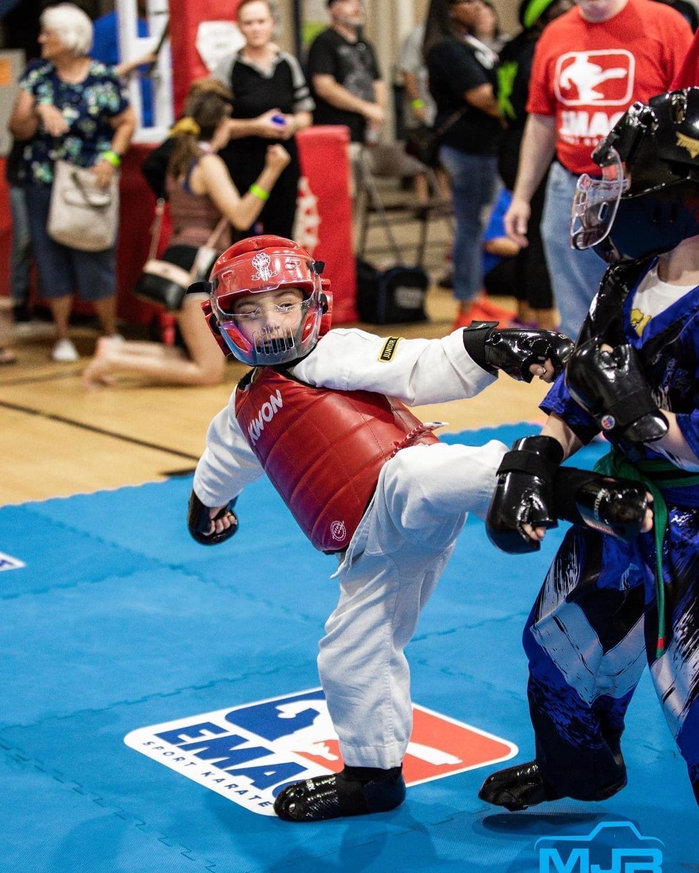 Two young boys are practicing martial arts on a mat that says mma