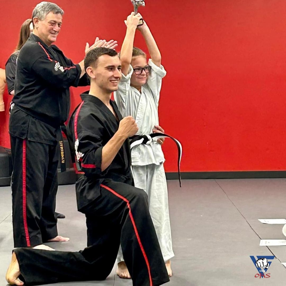 A group of martial arts students are posing for a picture