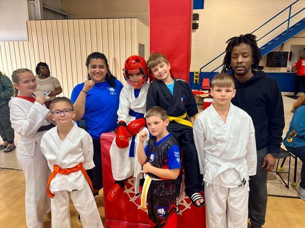 A group of kids are posing for a picture in a gym.
