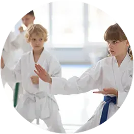 A group of children are practicing karate in a gym.