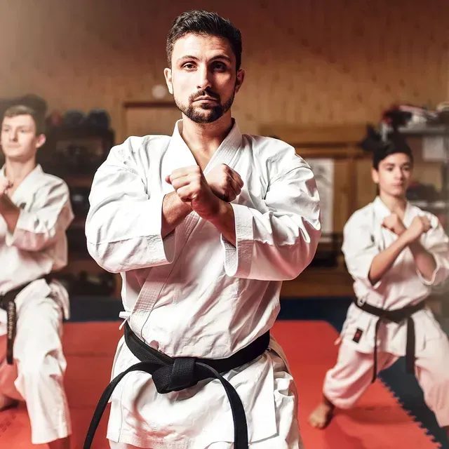 A group of men are practicing karate in a gym.