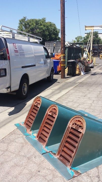 White van parked near industrial area. Green vents in foreground.