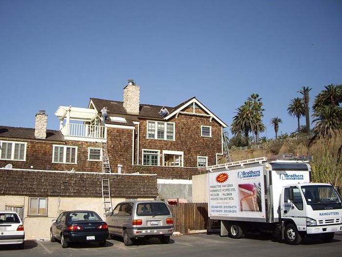 A large wooden house with a moving truck parked out front.