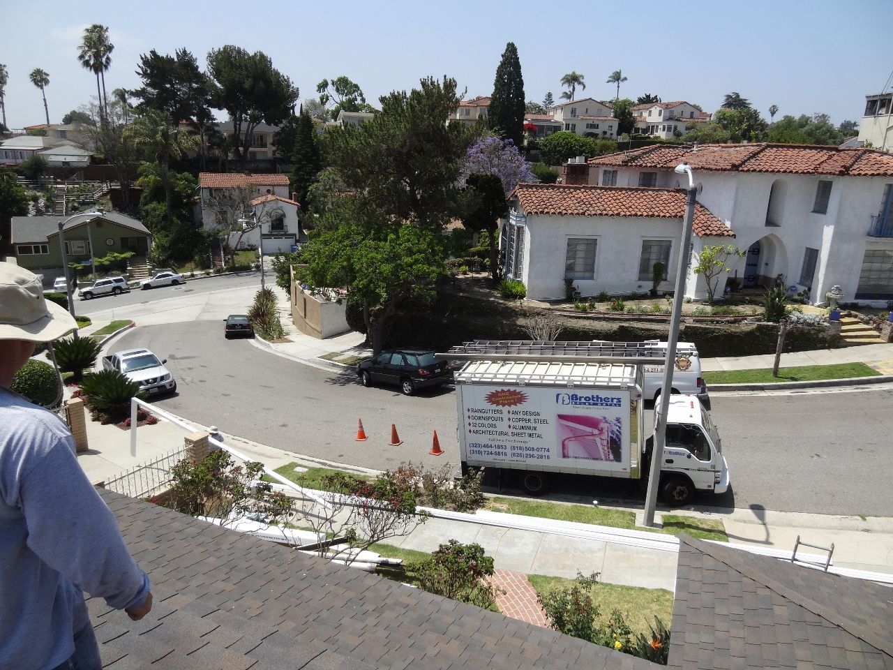 View from rooftop of neighborhood street with white truck, houses, and a person.
