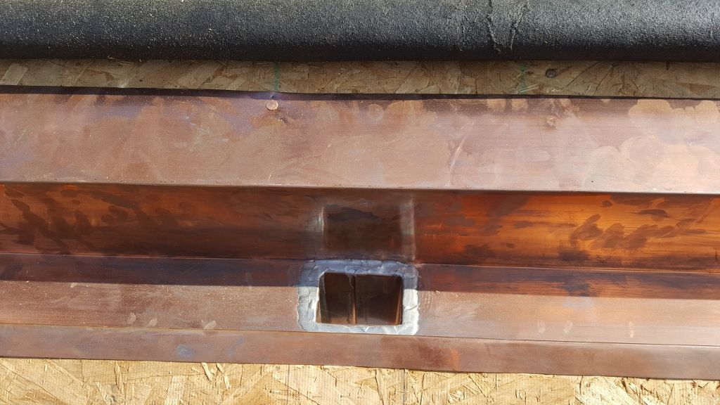 Copper gutter with square downspout opening.