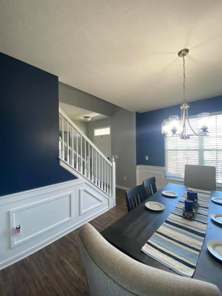 A man is standing next to a ladder in an empty room.