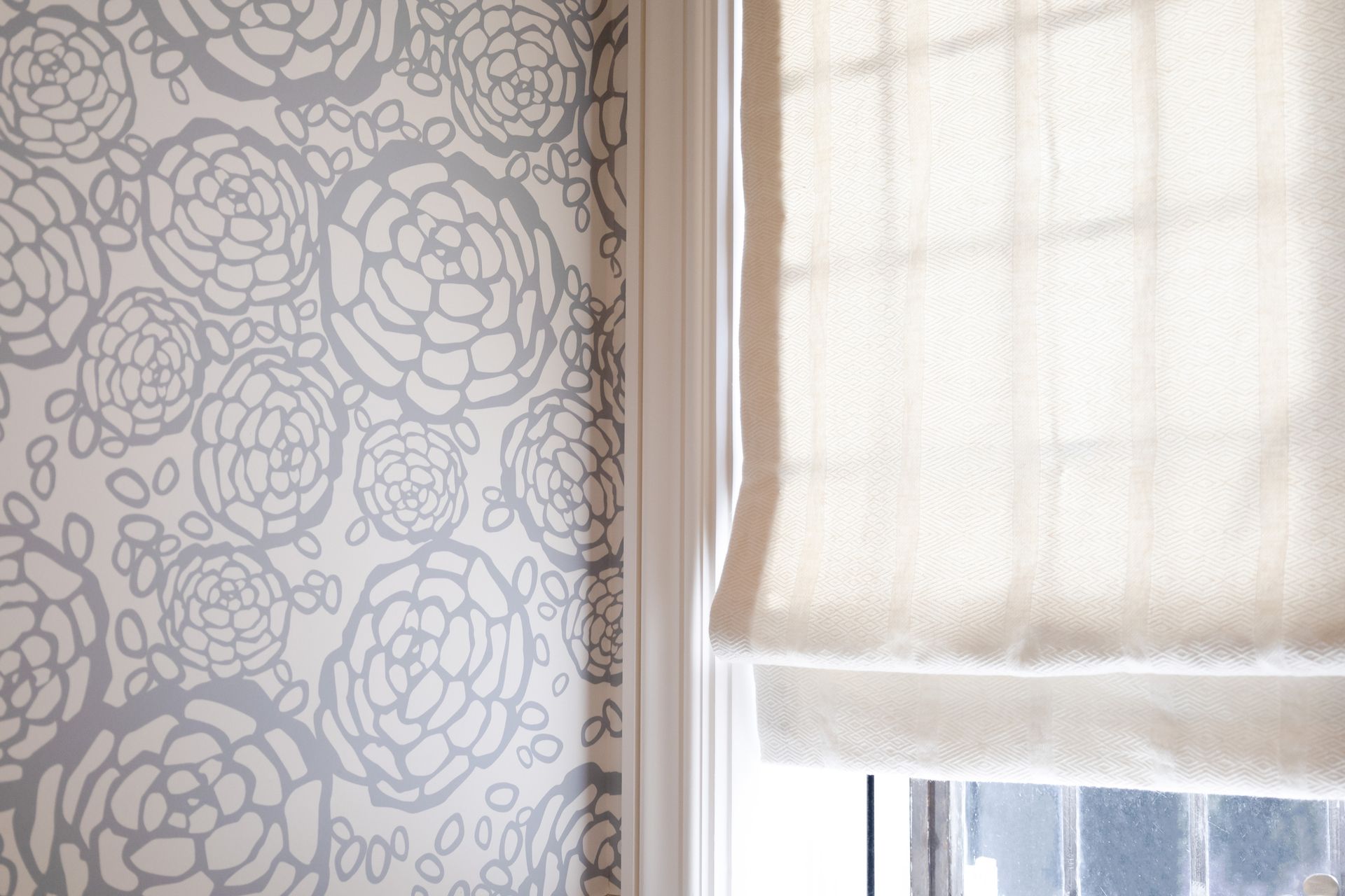 A person is peeling off a piece of wallpaper from a brick wall.