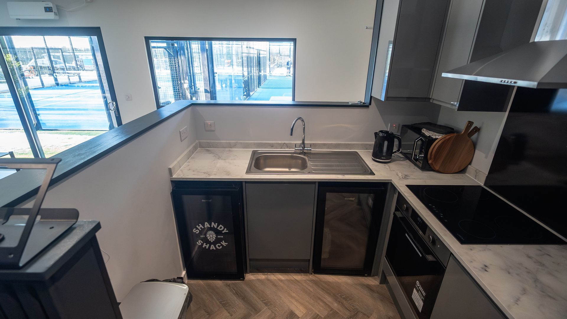 When UK Padel set out to elevate their Holmer Green venue, they weren’t just looking for a building. They needed a community anchor, a modern, durable and welcoming clubhouse that could keep pace with the sport’s explosive growth. Somewhere players could gather, coaches could meet and visitors could feel part of something bigger.
Bloxi was brought in to design and build a high‑performance clubhouse that delivered all of that and more: a hospitality‑ready kitchen, two toilets including an accessible WC, a club lounge, changing rooms a patio area, all within a compact footprint that respected the courts and the flow of play.