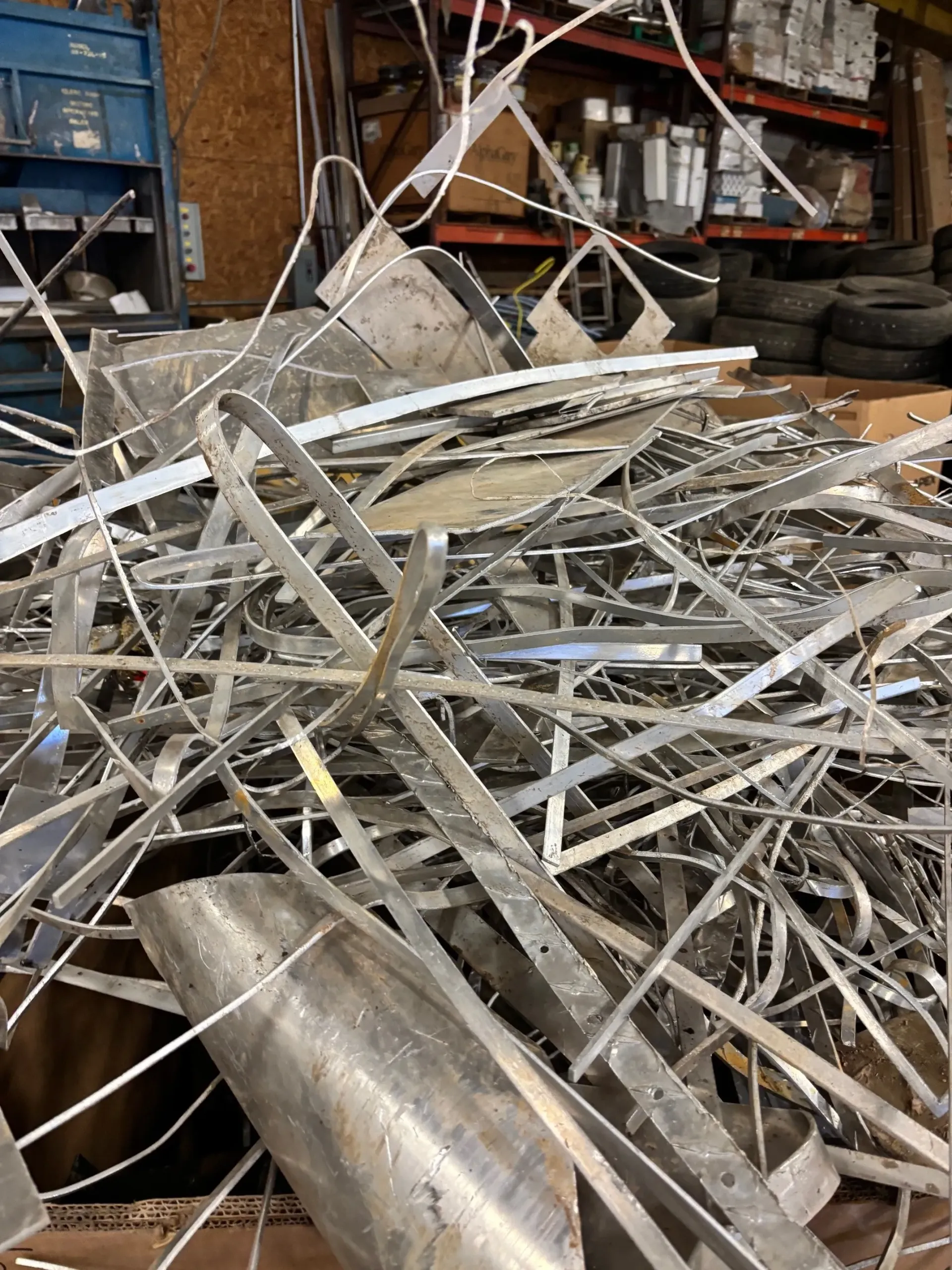 A pile of scrap metal is sitting on top of a table in a warehouse.