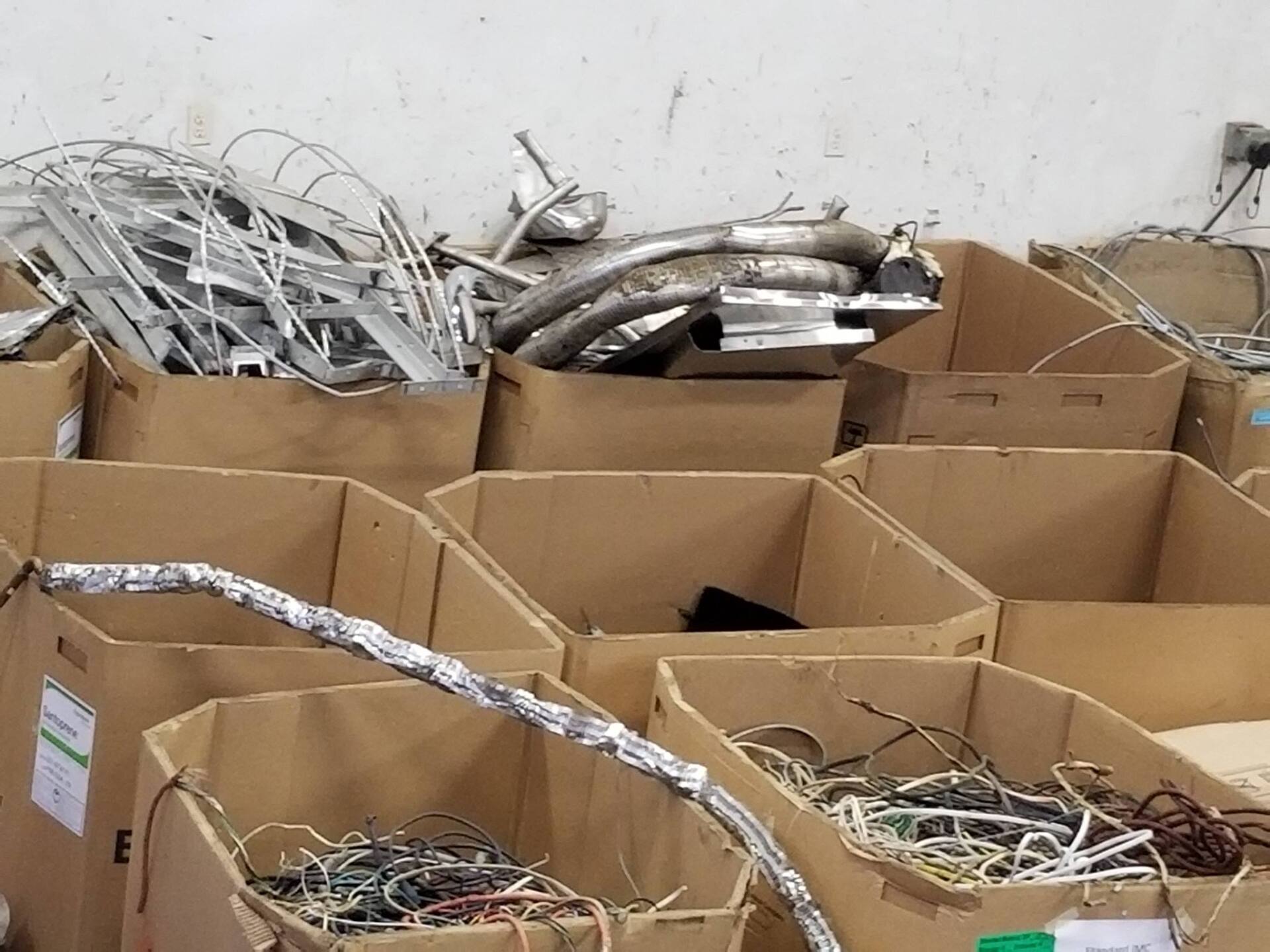 A bunch of cardboard boxes filled with scrap metal