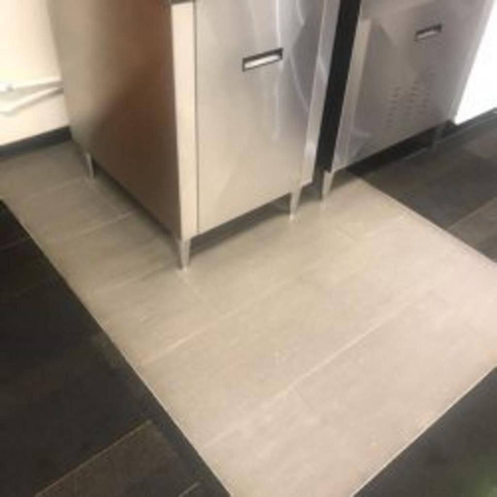 A kitchen with stainless steel cabinets and a tiled floor.