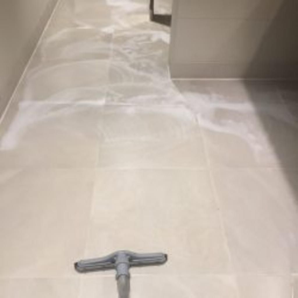 A vacuum cleaner is sitting on a tiled floor in a room.